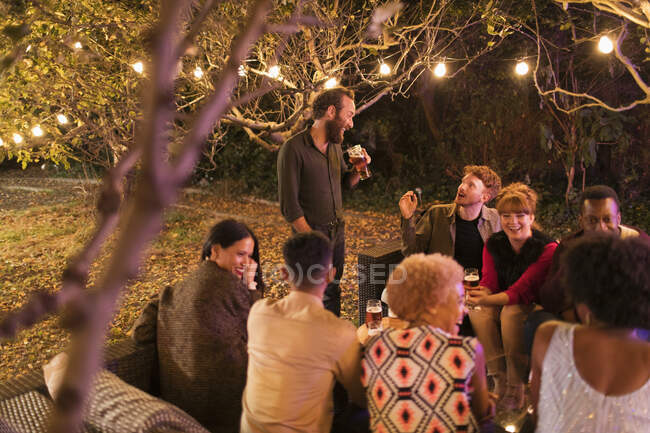 Друзі говорять і п'ють на садовій вечірці — стокове фото