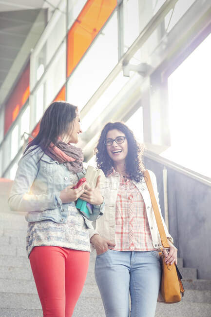 Happy young women friends descending urban stairs — Stock Photo