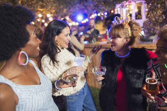 Happy women friends drinking cocktails at party — Stock Photo