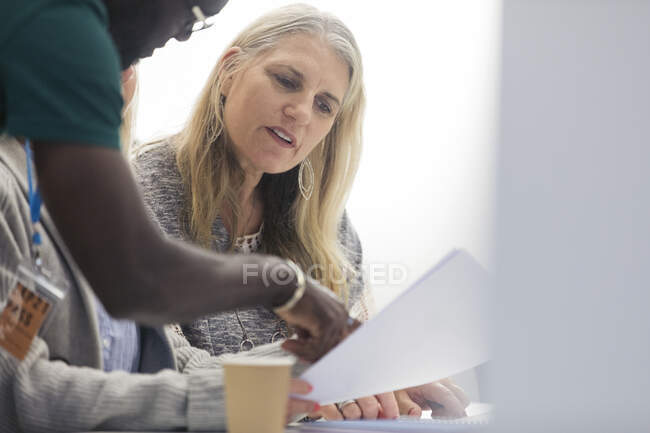 Community college instructor helping mature student in classroom — Stock Photo
