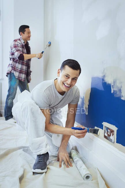 Portrait happy man painting wall — Stock Photo