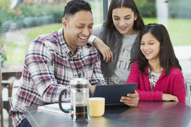 Buon padre e figlie utilizzando tablet digitale in cucina mattina — Foto stock