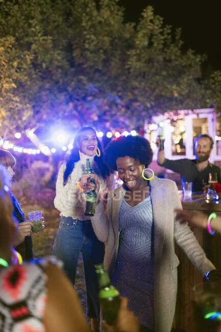 Felices amigos bailando y bebiendo en la fiesta del jardín - foto de stock