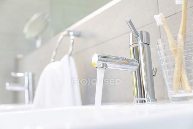 Acqua che scorre dal rubinetto del bagno in acciaio inossidabile — Foto stock