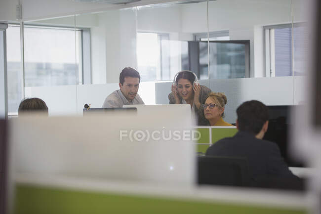 Ділові люди зустрічаються за комп'ютером у офісі відкритого плану — стокове фото