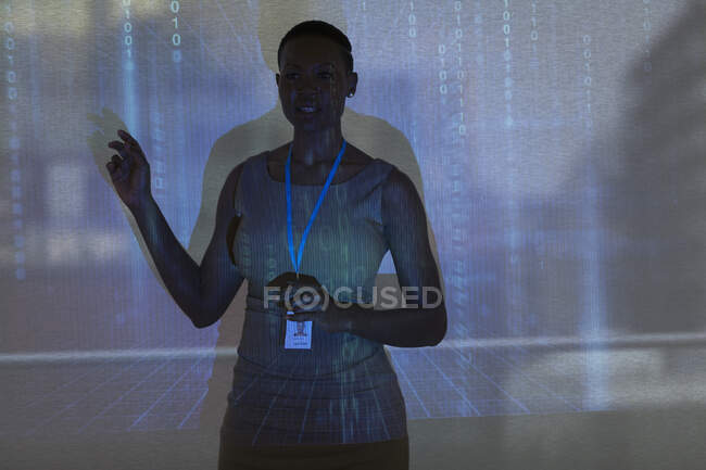 Femme d'affaires menant la réunion à l'écran de projection avec le code binaire — Photo de stock