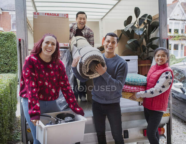 Porträt glückliche Freunde beim Entladen von Umzugswagen in Einfahrt — Stockfoto