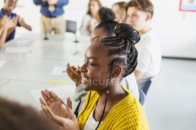 Lächelnde Gymnasiastin klatscht im Klassenzimmer — Stockfoto