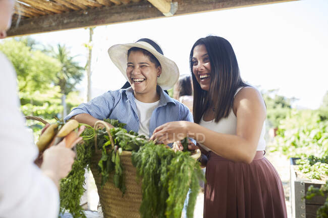 Happy young women shopping at farmers market — Stock Photo