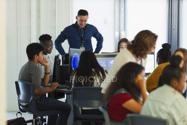 Junior high students and teacher using computers in computer lab — Stock Photo
