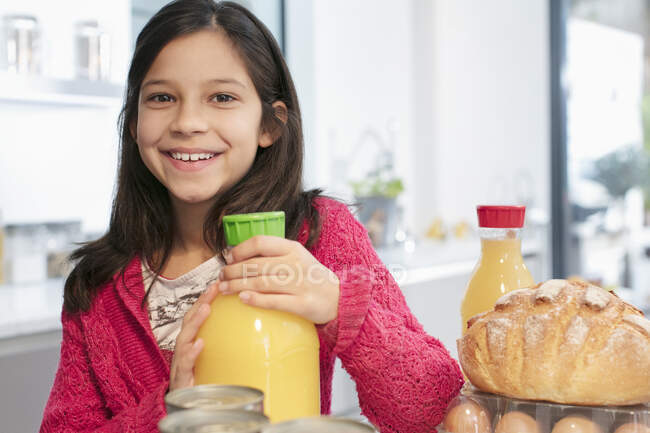 Menina sorrindo retrato com suco de laranja na cozinha — Fotografia de Stock