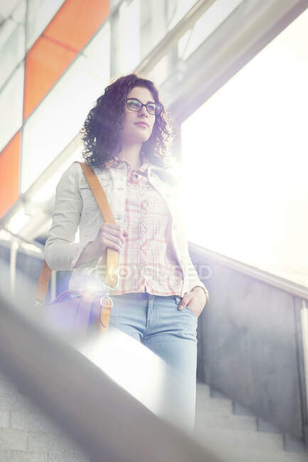 Confident young woman descending stairs — Stock Photo
