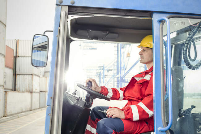 Dock worker operating cargo container forklift at shipyard — Stock Photo
