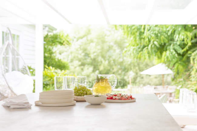 Lemonade and grapes on summer patio table — Stock Photo