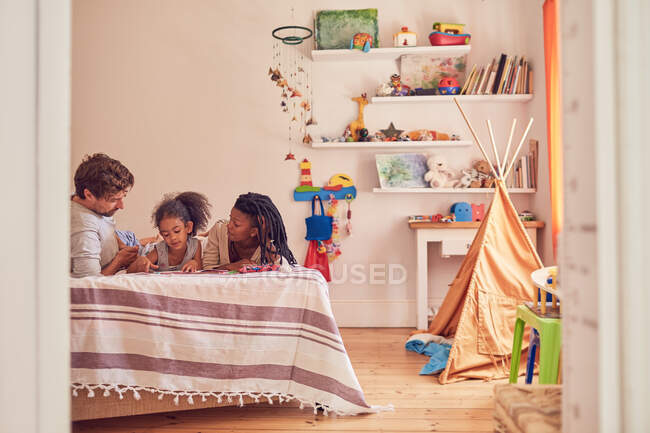 Young family on bed — Stock Photo