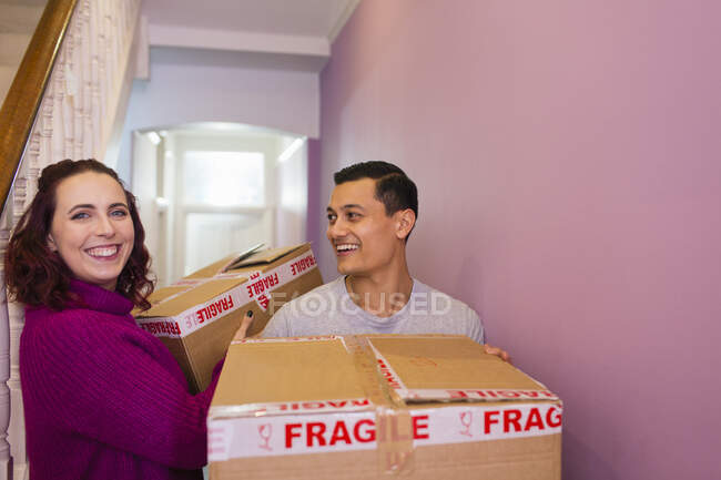 Ritratto felice coppia trasloco casa, portando scatole di cartone in corridoio — Foto stock