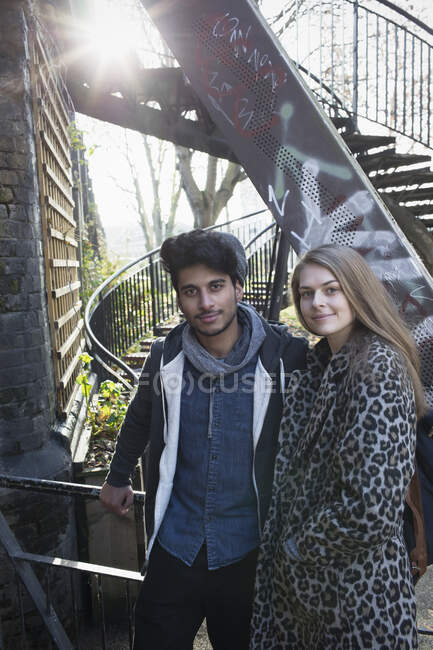 Portrait jeune couple confiant à côté des escaliers urbains — Photo de stock