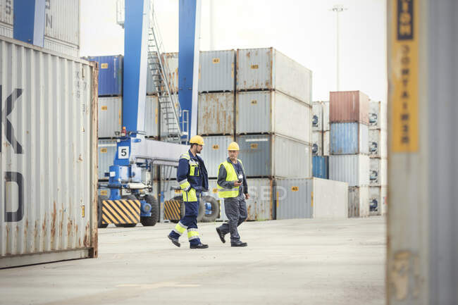 Trabajadores portuarios caminando y hablando en el astillero - foto de stock