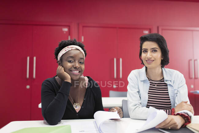 Ritratto fiducioso, sorridente studenti universitari di comunità femminile con scartoffie in classe — Foto stock