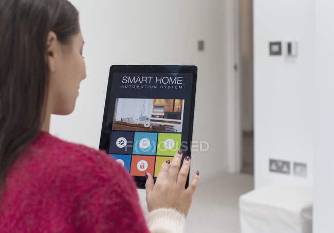 Mulher usando o sistema de automação residencial inteligente com tablet digital — Fotografia de Stock