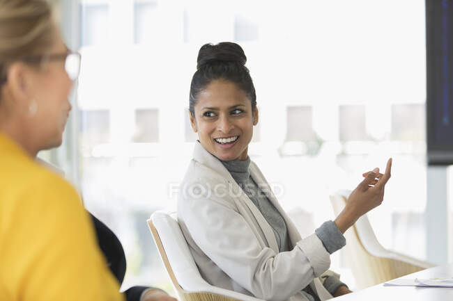 Sonriente mujer de negocios hablando en la reunión - foto de stock