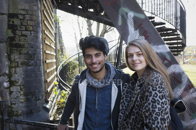 Retrato feliz pareja joven en las escaleras urbanas - foto de stock
