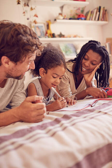 Junge Familie Färbung auf Bett — Stockfoto