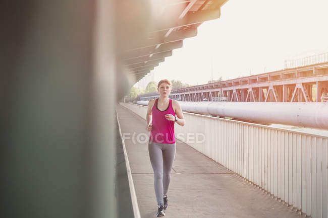 Jovem mulher correndo na plataforma da estação ferroviária urbana — Fotografia de Stock