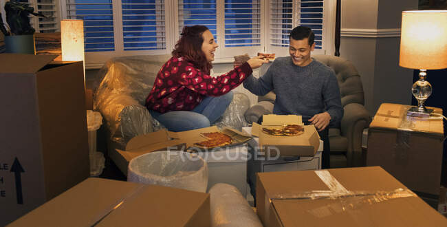 Casal feliz fazendo uma pausa de se mudar, comer pizza — Fotografia de Stock