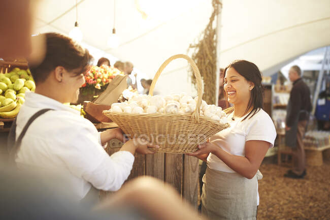 Arbeiterinnen tragen Korb mit frischem Knoblauch auf Bauernmarkt — Stockfoto