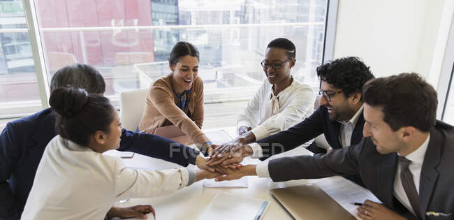 Business people joining hands in conference room meeting — Stock Photo