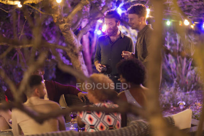 Friends talking and drinking at garden party — Stock Photo