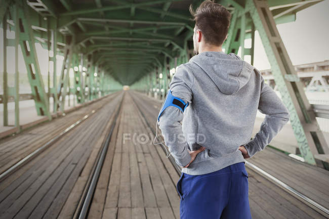 Мужчина бегун слушает музыку с наушниками и смартфоном — стоковое фото