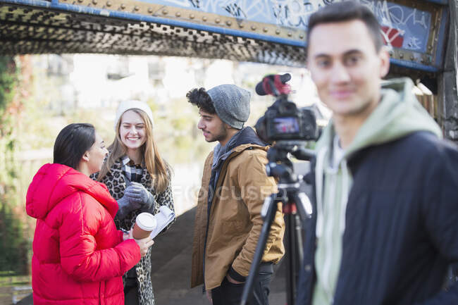 Jovens adultos vlogging sob ponte urbana — Fotografia de Stock