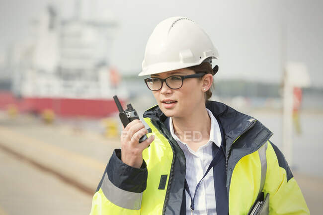 Mulher trabalhadora portuária com walkie-talkie no estaleiro — Fotografia de Stock