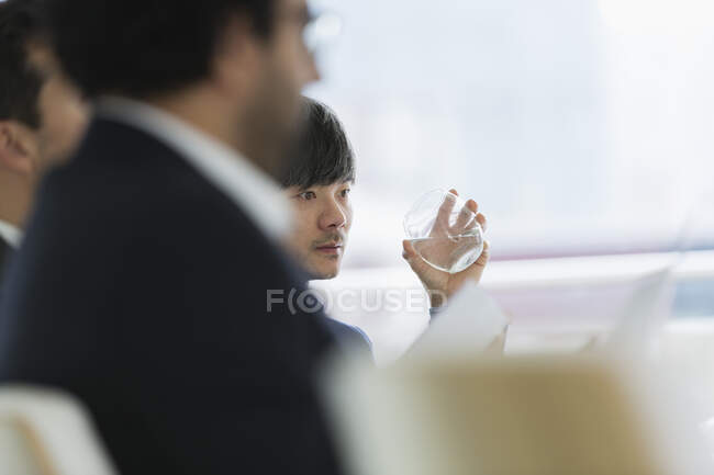 Homem de negócios focado água potável na reunião da sala de conferências — Fotografia de Stock