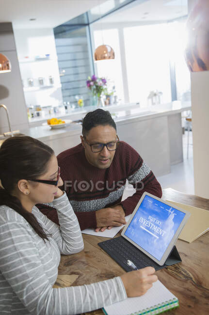 Planejamento financeiro de casal em tablet digital na mesa de jantar — Fotografia de Stock