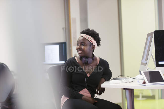 Sorrindo jovem estudante universitário comunidade feminina usando computador em sala de aula — Fotografia de Stock