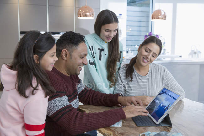 Familie nutzt digitales Tablet am Küchentisch — Stockfoto