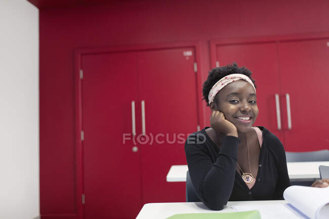 Retrato confiado joven estudiante universitaria comunitaria en el aula - foto de stock
