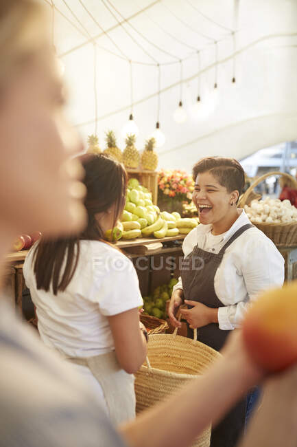 Mujer sonriente trabajando en el mercado de agricultores - foto de stock