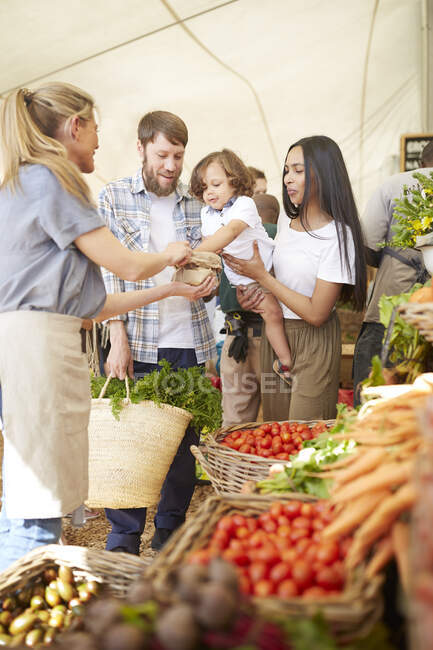 Acquisti di giovani famiglie al mercato agricolo — Foto stock