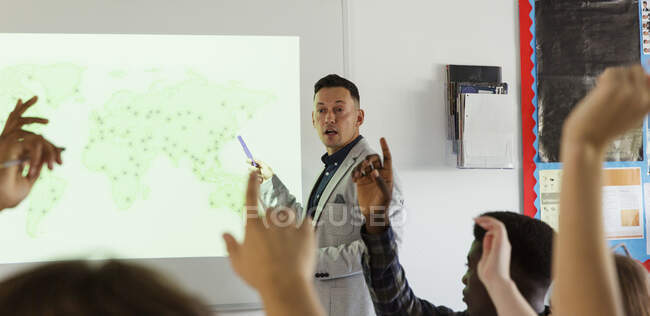 Männlicher Gymnasiallehrer leitet Unterricht an Projektionswand im Klassenzimmer — Stockfoto