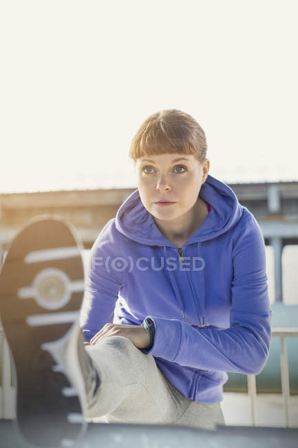 Молода жінка бігун розтягує ногу — стокове фото