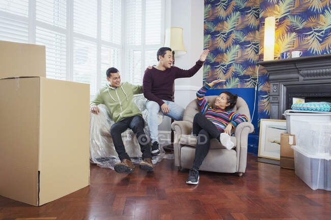 Amigos felizes fazendo uma pausa de se mover, comemorando, high-fiving na sala de estar — Fotografia de Stock