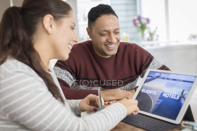 Happy couple planning vacation at digital tablet — Stock Photo