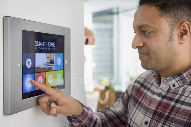 Man setting smart home navigation system alarm at touch screen — Stock Photo