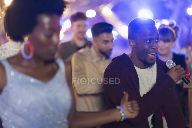 Amigos assinando karaoke e dançando na festa — Fotografia de Stock