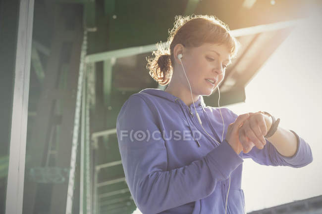 Young woman checking time on urban train station platform — Stock Photo