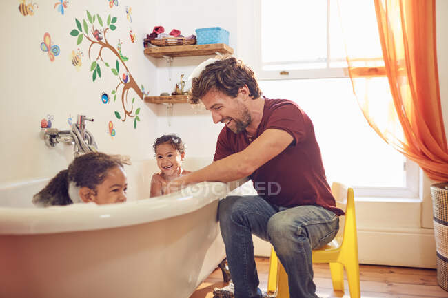 Батько дає маленьким донькам бульбашкову ванну — стокове фото